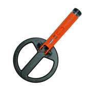 A handheld metal detector with a large black circular coil and an orange handle, shown on a plain white background.