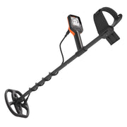 A black metal detector with an orange accent on the control unit, featuring a circular coil, long handle, and carrying strap, shown against a plain white background.