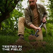 Man digging in the dirt with a tool, surrounded by greenery, with text 'Tested in the Field'.